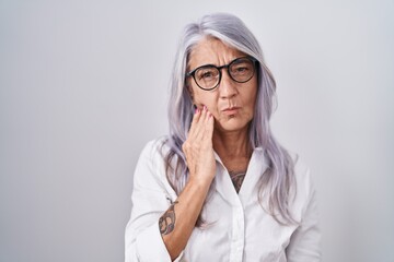 Sticker - Middle age woman with tattoos wearing glasses standing over white background touching mouth with hand with painful expression because of toothache or dental illness on teeth. dentist