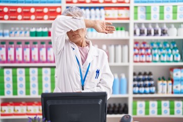 Sticker - Middle age woman with tattoos working at pharmacy drugstore covering eyes with arm, looking serious and sad. sightless, hiding and rejection concept