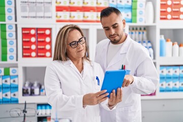 Wall Mural - Man and woman pharmacist using touchpad working at pharmacy