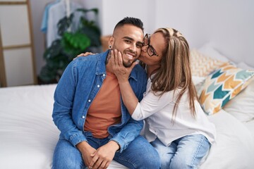 Poster - Man and woman mother and son sitting on bed kissing at bedroom