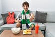 © Krakenimages.com - Young hispanic man football hooligan cheering game at home smiling friendly offering handshake as greeting and welcoming. successful business.