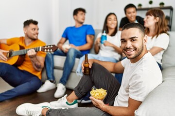 Poster - Group of young friends on party smiling happy and playing classical guitar at home.