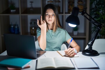 Wall Mural - Teenager girl doing homework at home late at night showing middle finger, impolite and rude fuck off expression