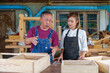 © ND STOCK - Tutor With Female Carpentry Student In Workshop Studying For Apprenticeship At College ,Teacher explaining a structure students while standing in a woodwork class