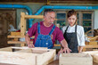 © ND STOCK - Tutor With Female Carpentry Student In Workshop Studying For Apprenticeship At College ,Teacher explaining a structure students while standing in a woodwork class