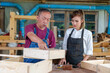 © ND STOCK - Tutor With Female Carpentry Student In Workshop Studying For Apprenticeship At College ,Teacher explaining a structure students while standing in a woodwork class