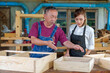 © ND STOCK - Tutor With Female Carpentry Student In Workshop Studying For Apprenticeship At College ,Teacher explaining a structure students while standing in a woodwork class