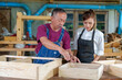 © ND STOCK - Tutor With Female Carpentry Student In Workshop Studying For Apprenticeship At College ,Teacher explaining a structure students while standing in a woodwork class