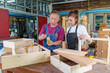© ND STOCK - A tutor with a Female carpenter student in a workshop studying for an apprenticeship at a college using a tape measure.