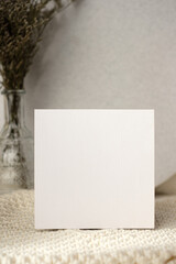 Wall Mural - mockup blank wedding  invitation card with flower in vase on white soft wicker tablecloth