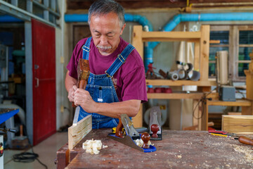 Wall Mural - carpenter hands working with a chisel and hammer on wooden workbench