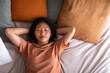 © Daniel - Top view of Asian teen girl lying down on bed relaxing with eyes closed. Copy space. Lifestyle
