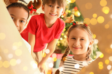 Poster - Cute little children opening box with Christmas gift, view from inside