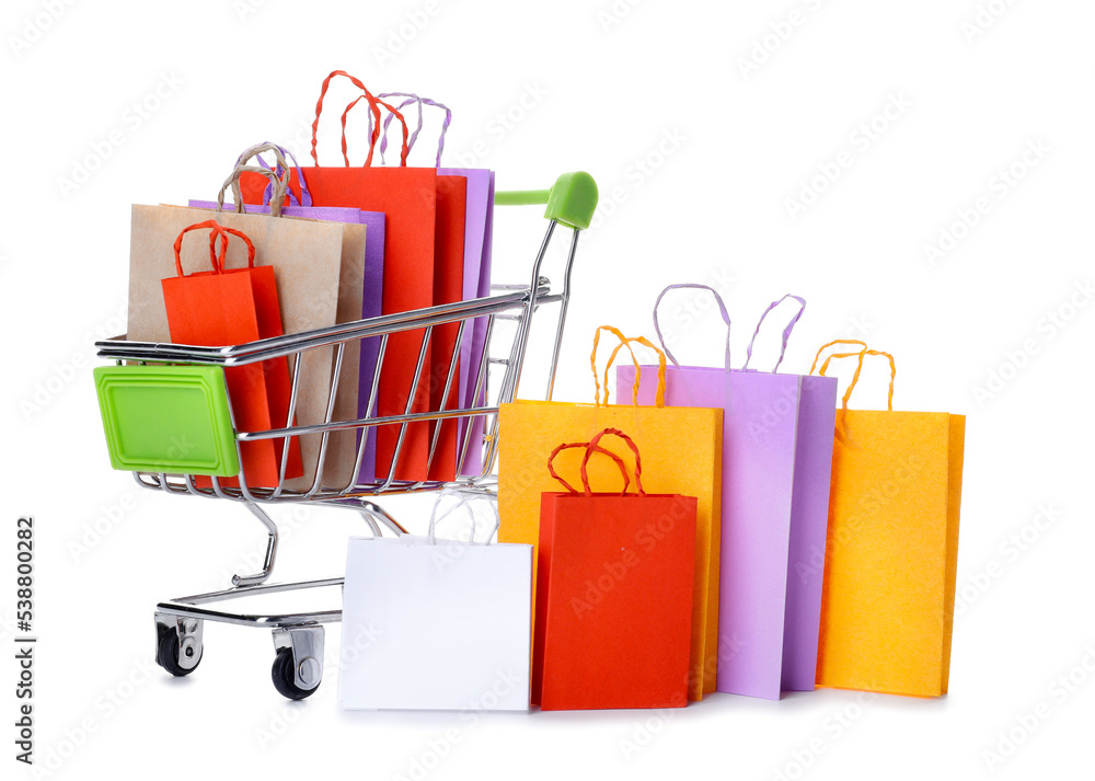 Shopping cart with different paper bags on white background