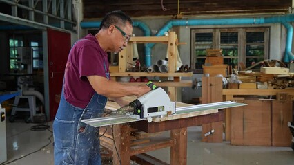 Wall Mural - Miter saw with a large metal blade in the hands of a carpenter. Working tool for sawing wooden planks.the sawing process. Labor protection and safety rules for the use of power tools.Building a house.