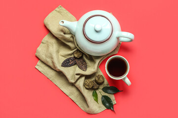 Napkin with dry pressed puer tea, cup and teapot on red background