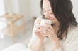 © lielos - 朝、温かい飲み物を飲む女性
