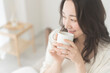 © lielos - 朝、温かい飲み物を飲む女性
