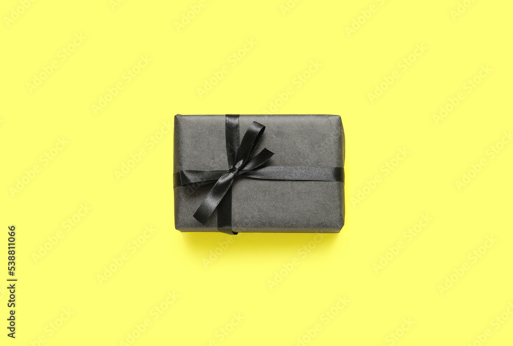 Gift box on yellow background. Black Friday sale