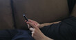 © GCapture - Closeup young man use smartphone working from home lying on couch side view