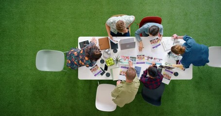 Wall Mural - Meeting, collaboration and teamwork by business people working on creative, design and proposal from above. Planning, partner and green business innovation with corporate employee group sharing idea