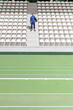 © Westend61 - Sportsman standing amidst chairs in stadium