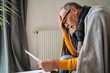© Westend61 - Worried man with head in hand looking at heating bill in home