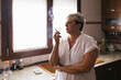 © Westend61 - Depressed woman smoking cigarette in kitchen at home