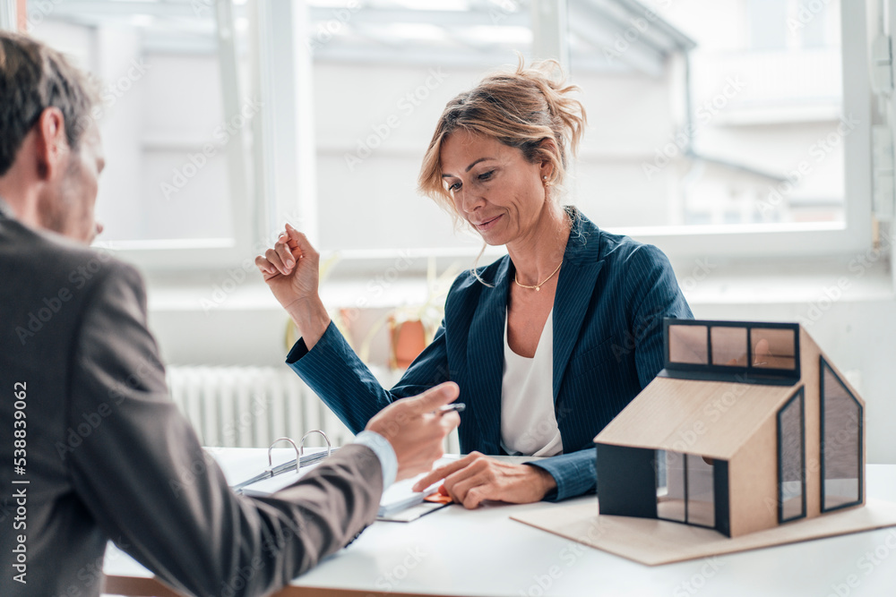 Real estate agent assisting client signing agreement at office Stock ...