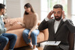 © Prostock-studio - Couple arguing at therapy session, male therapist grabbing head