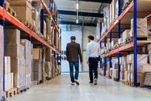 Businessman With Colleague Walking At Warehouse