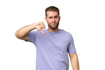 Wall Mural - Young handsome caucasian man isolated on green chroma background showing thumb down with negative expression