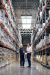 © Westend61 - Senior businesswoman with colleague discussing in warehouse
