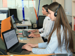 Wall Mural - Attractive positive young businesspeople and colleagues in a call center office.