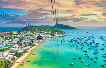 The longest cable car ride in the world, Phu Quoc island in South Vietnam, sunset sky. Below is traditional fishermen boats lined in the harbor of An Thoi town in the popular Hon Thom island. 