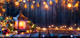 Fototapeta  - Christmas Lantern Glowing On Wooden Table With Decoration And String Lights - Bokeh And Glittering Effect On Background