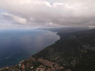 Canvas Print - View of coast of Cala Gonone, surrounded by mountain range with green forest in Sardinia, Italy.