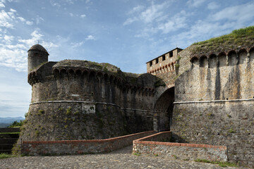 Towers and walls with bridge and moat of the medieval fortress of Sarzanello in Sarzana, beautiful town in Liguria, Italy