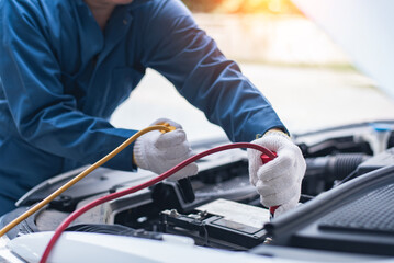 Sticker - Battery charging. Terminals and hands. auto repair a gas station, hand up close using jumper wires to electrically charge a car battery.