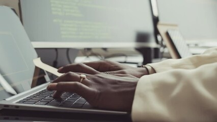 Slowmo closeup of hands of unrecognizable African American female programmer typing programming code on laptop in office
