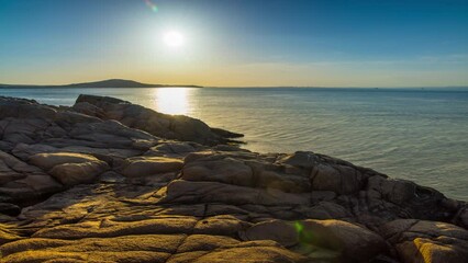 Wall Mural - A beach with sand and stones near the Black Sea under sunset light in Bulgaria