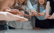 © ASDF - group of smiling young people joining their hands