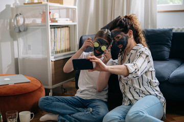 Wall Mural - mother and daughter skin cleansing using clay face mask