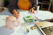 © Alliance - piggy bank and accountant woman with calculator and documents