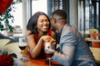 Romantic black couple sitting at restaurant wearing elegant clothes