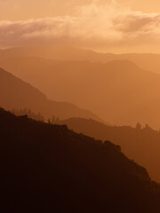 Wall Mural - Layer of mountains under the golden sunlight.