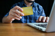 © Anucha - Online payment, Man's Hands holding credit card and using laptop, online credit card payment for purchases from online, Online shopping.