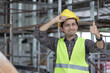© anut21ng Stock - portrait of asian male construction worker hands on safety helmet and thumbs up sign and smiles cheerfully at construction site