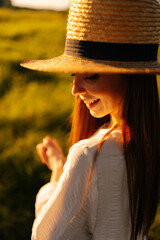 Wall Mural - close-up vertical face shot of smiling woman with closed eyes wearing straw hat and white dress stan