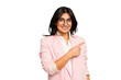 Young Indian business woman wearing a pink suit isolated smiling and pointing aside, showing something at blank space.